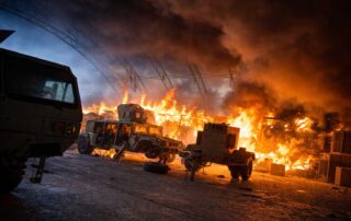 Large fire and explosions at a military base with burning vehicles and heavy smoke after an attack at Al Dhafra Air Base in the United Arab Emirates